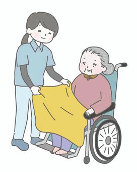 介護士が膝掛けをかけるおばあさん 介護,高齢者,老人,介護士,介護施設,デイサービス,車椅子,ブランケット,冬,シニアのイラスト素材