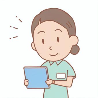 Upper body of a young female care worker looking at a tablet, , JPG, PNG and EPS