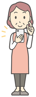 スマホをタップして操作するおばさん スマホ,女性,人,主婦,中年,シニア,エプロン,ママ,お母さん,おかんのイラスト素材