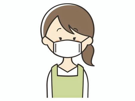 マスクをしたエプロンの女性