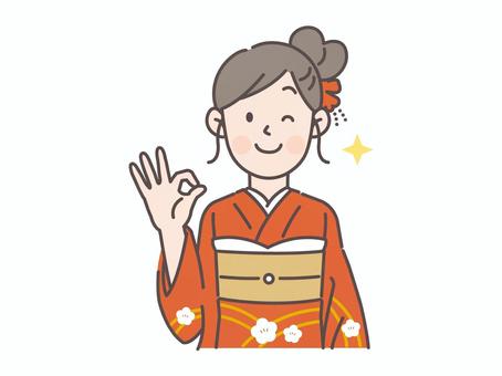 OKサインを出しながらウィンク振袖の女性