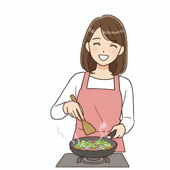 エプロンをして料理をする女性