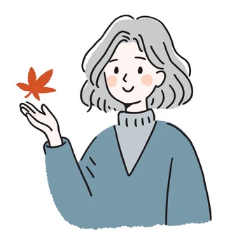 紅葉を手にしたセーターの女性