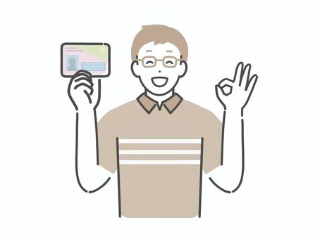 マイナカードを持ちOKするメガネの男性 男性,人物,マイナンバーカード,マイナンバー,カード,マイナ保険証,保険証,免許証,ok,いいねのイラスト素材