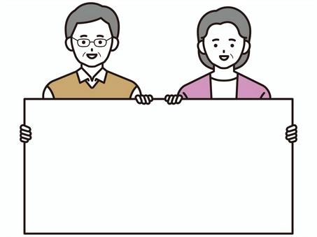 ボードを持つシニア夫婦(カラー)2