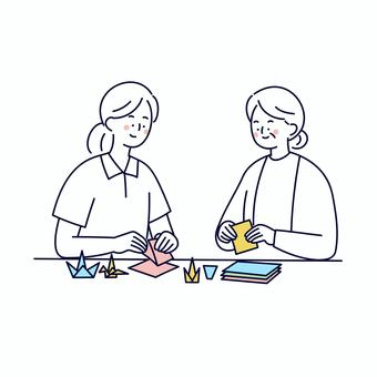介護士と高齢女性の折り紙レクリエーション