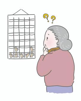 お薬カレンダーを見て困惑する高齢女性 高齢者,薬カレンダー,服薬管理,飲み忘れ,薬,管理,介護,医療,シニア,老人のイラスト素材