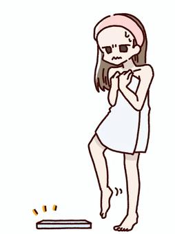 恐る恐る体重計に乗ろうとする女性