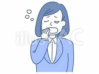 大きな口であくびをするスーツの若い女性