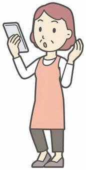  スマホで通話しているエプロンの中年女性 通話,おばさん,人,女性,中年,おばちゃん,シニア,ママ,主婦,ヘルパーのイラスト素材