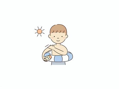 日焼け止めを塗る浮き輪を持った少年