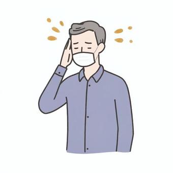 頭痛でこめかみを押さえるマスクの男性