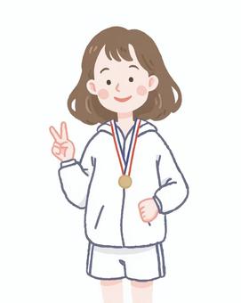 金メダルをかけてピースする女性