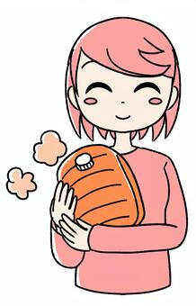 桃色の女の子が湯たんぽ抱いている ピンク,手描き,湯たんぽ,ゆたんぽ,防寒,冷え対策,寒さ対策,冷え性,あたたかい,温めるのイラスト素材